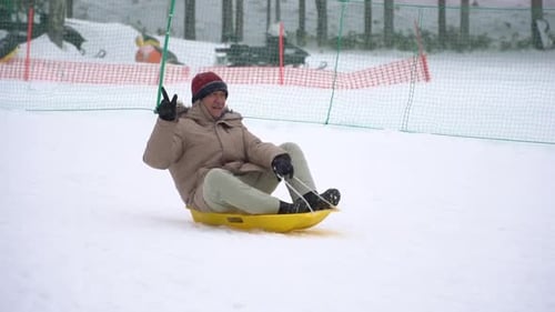 Vieil homme asiatique jouant au traîneau sous la neige