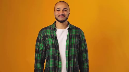 Handsome African American Guy Standing Against Yellow Background and Smiling