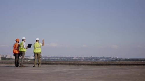 Anonymous Builders with Laptop on Construction Site