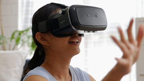 Young Adult Using VR Headset Interactively Indoors