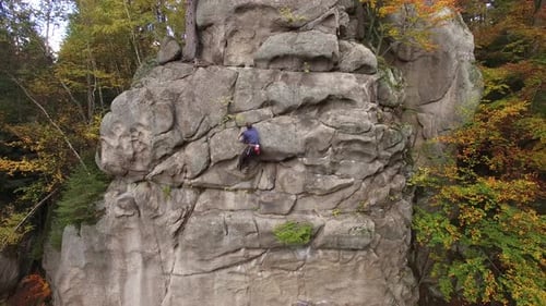 Man Rock Climbing on a Large Cliff Face