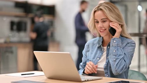 Woman Talking on Smartphone in Modern Workplace