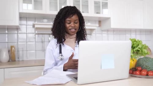 Woman Doctor Telehealth Session at Kitchen Table