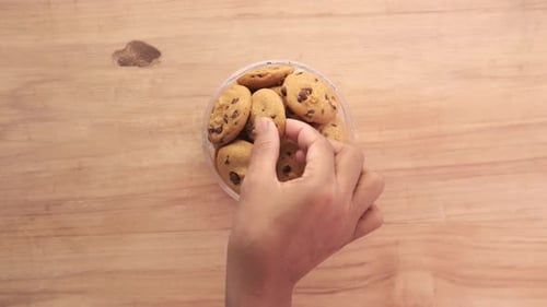 Top View of Hand Pick Sweet Cookies on Wooden Table
