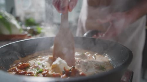 Cooking food with cream and sauce in kitchen