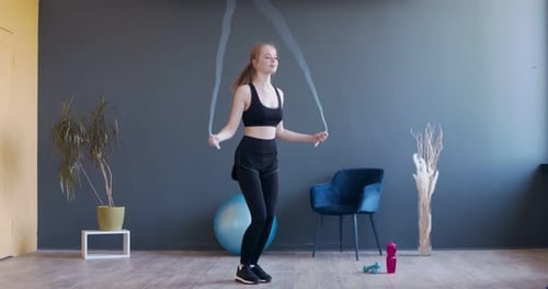 Woman Exercising with Jump Rope in Bright Home