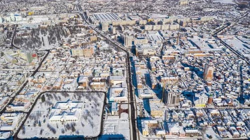 Beautiful winter flight over the city. The whole city is covered in snow. Sunny winter day.