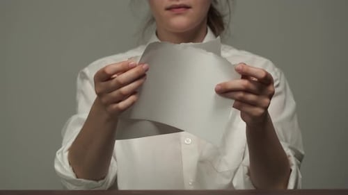 Woman Tearing a Piece of White Paper
