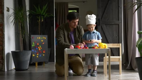 Father and Son Play with Toy Vegetables