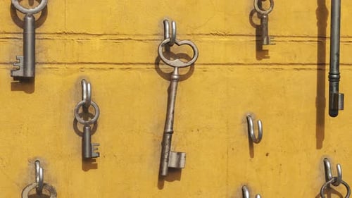 Animation of a key hanging on the hook with other keys around. Yellow wall. 4kHD
