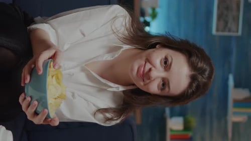 Vertical Video Caucasian Adult Looking at Camera While Having Bowl of Chips