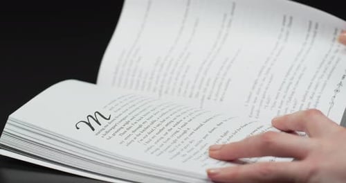 Hands Turning Pages of a Book Close Up
