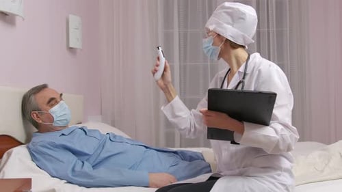 Doctor Checking Senior Patient Lying in Hospital Bed