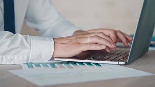 Hands Typing on Laptop in Office Workplace