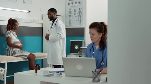 Pregnant Woman Consulting with Doctor in Hospital Office