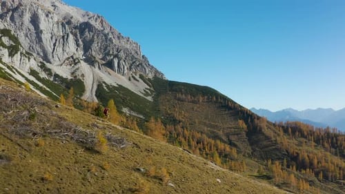 Woman Running Down Mountain Ridge in Autumn