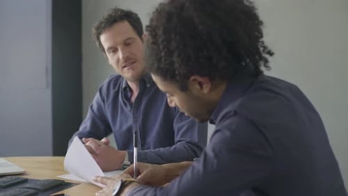 Two Men at Desk Signing Documents