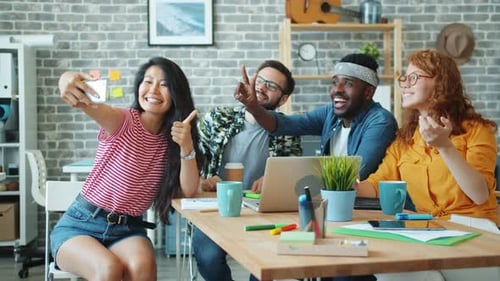 Multi-ethnic Team Taking Selfie in Office Showing Thumbs-up and OK Gestures