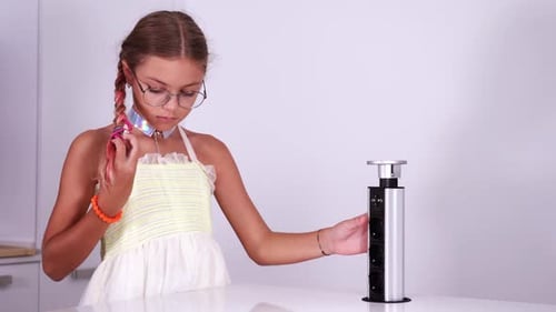 Une adolescente connecte le câble à la station de charge jouant au robot