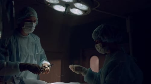 Professional Medical Workers Performing Operation in Dark Operating Theater