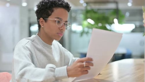 Young Adult Reviewing Documents in Office Setting