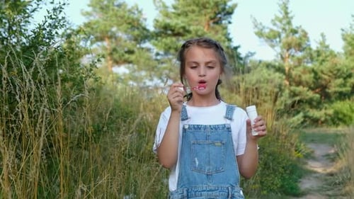 Little Girl Blowing Soap Bubbles in a City Park
