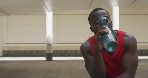 Fit Man Drinks Water and Checks Phone