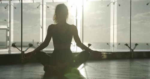 Junge schöne Frau meditiert während des Trainings. Sportliches Mädchen beim Yoga
