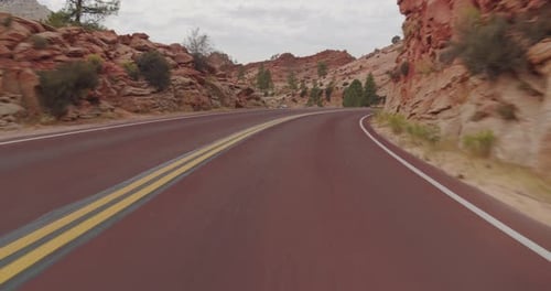 Driving Scenic Desert Road Through Red Rock Mountains