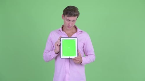 Young Adult Holds Up Digital Tablet With Green Screen