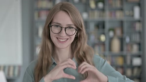 Smiling Woman Makes Heart Shape with Hands