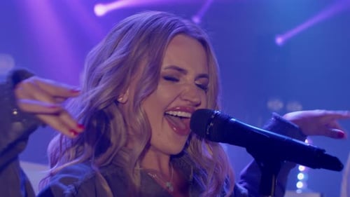 Blond Woman Singing on Stage at Concert