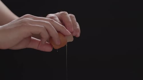 Hands Holding A Cracked Egg, Breaking An Egg
