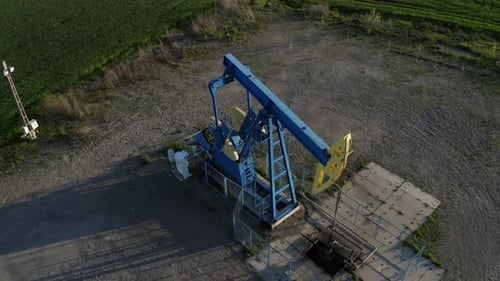 Oil Well Pumpjack Working in Rural Landscape