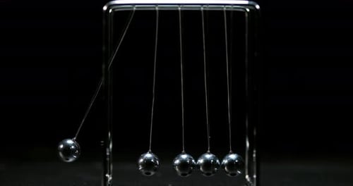 Pendulum, Newton's Cradle, One Ball hits Another against Black Background, Slow Motion 4K