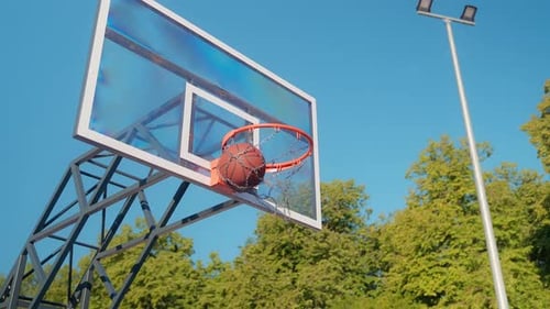 Basketball Swishes Through Net on Outdoor Court