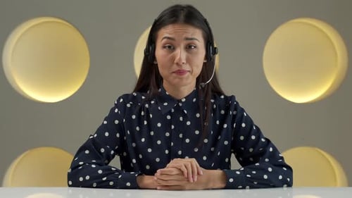 Woman With Headset Speaks in Modern Workplace Setting