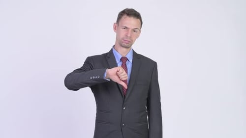 Studio Shot of Sad Businessman Giving Thumbs Down