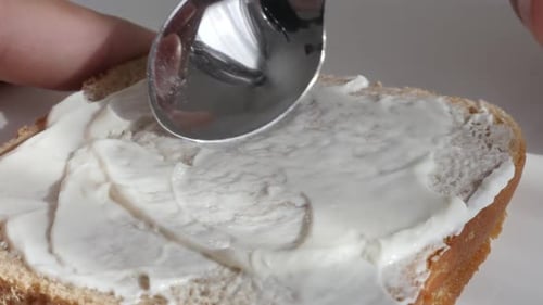 Spreading Cream Cheese on Bread With a Spoon