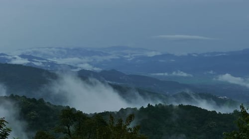 Lush Green Mountains with Rolling Clouds and Mist