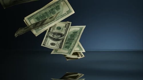Amerikanische 100-Dollar-Scheine fallen auf eine reflektierende Oberfläche