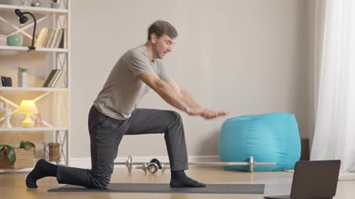 Man Stretching on Yoga Mat in Living Room