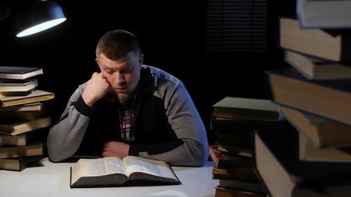 Man Leafing Through the Book, He Is Sleepy and Tired. Black Background
