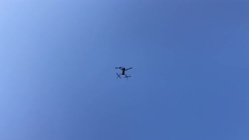 Drone Flying in a Bright Blue Sky