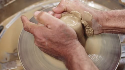 Potter's Hands Shaping Clay on Spinning Wheel