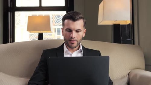 Portrait of Happy Business Man Enjoys Success on Laptop in Hotel Restaurant