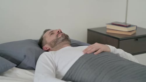 Homme éveillé dans son lit pensant