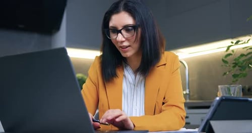 Woman Celebrates Success Working on Laptop at Home