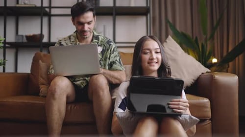 Man and Woman Using Electronics at Home