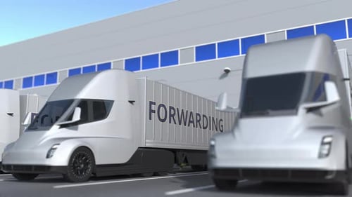 Trucks with FORWARDING Text Being Loaded or Unloaded at Warehouse